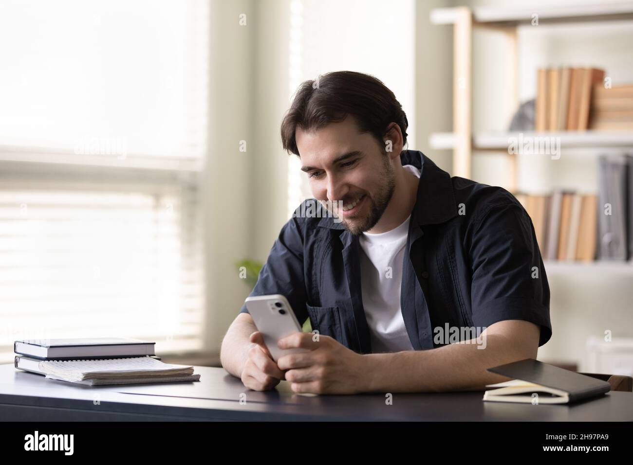 Happy guy enjoying virtual flirt on dating website app Stock Photo