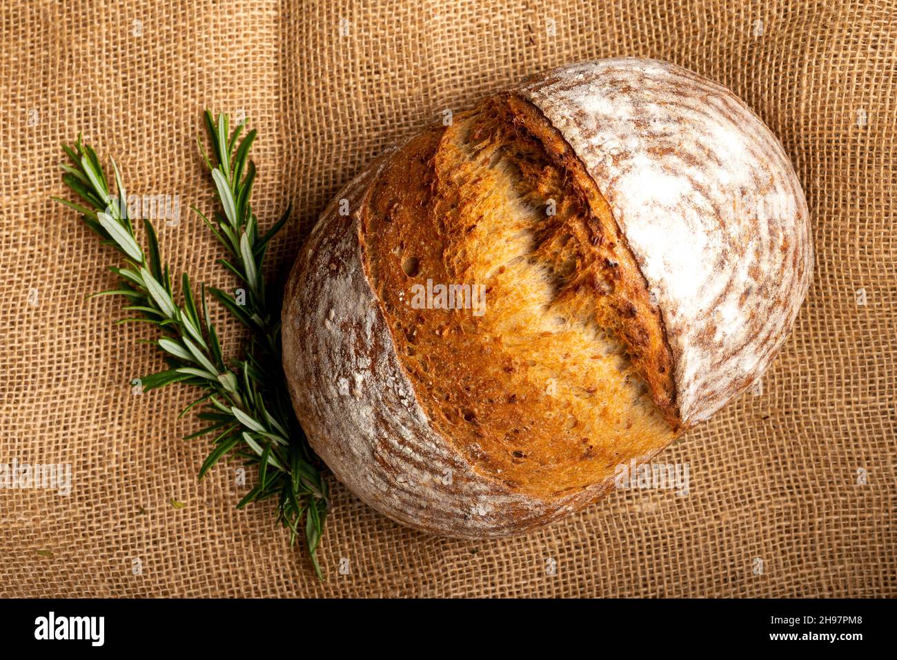 Sourdough bread with Italian herbs and rosemary isolated on burlap