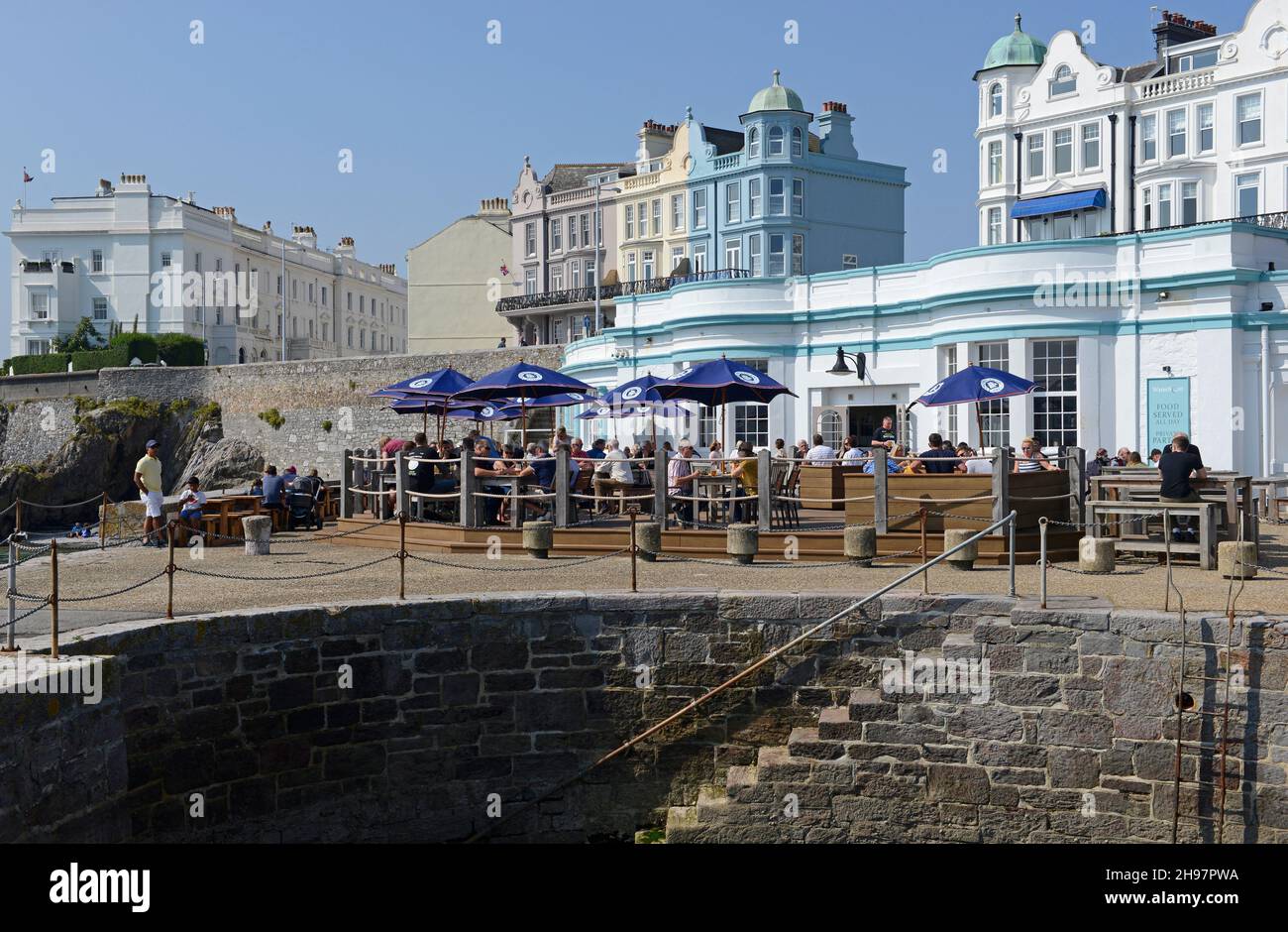 A restaurant on West Hoe Pier with many busy tables outside. Plymouth, Devon, UK Stock Photo