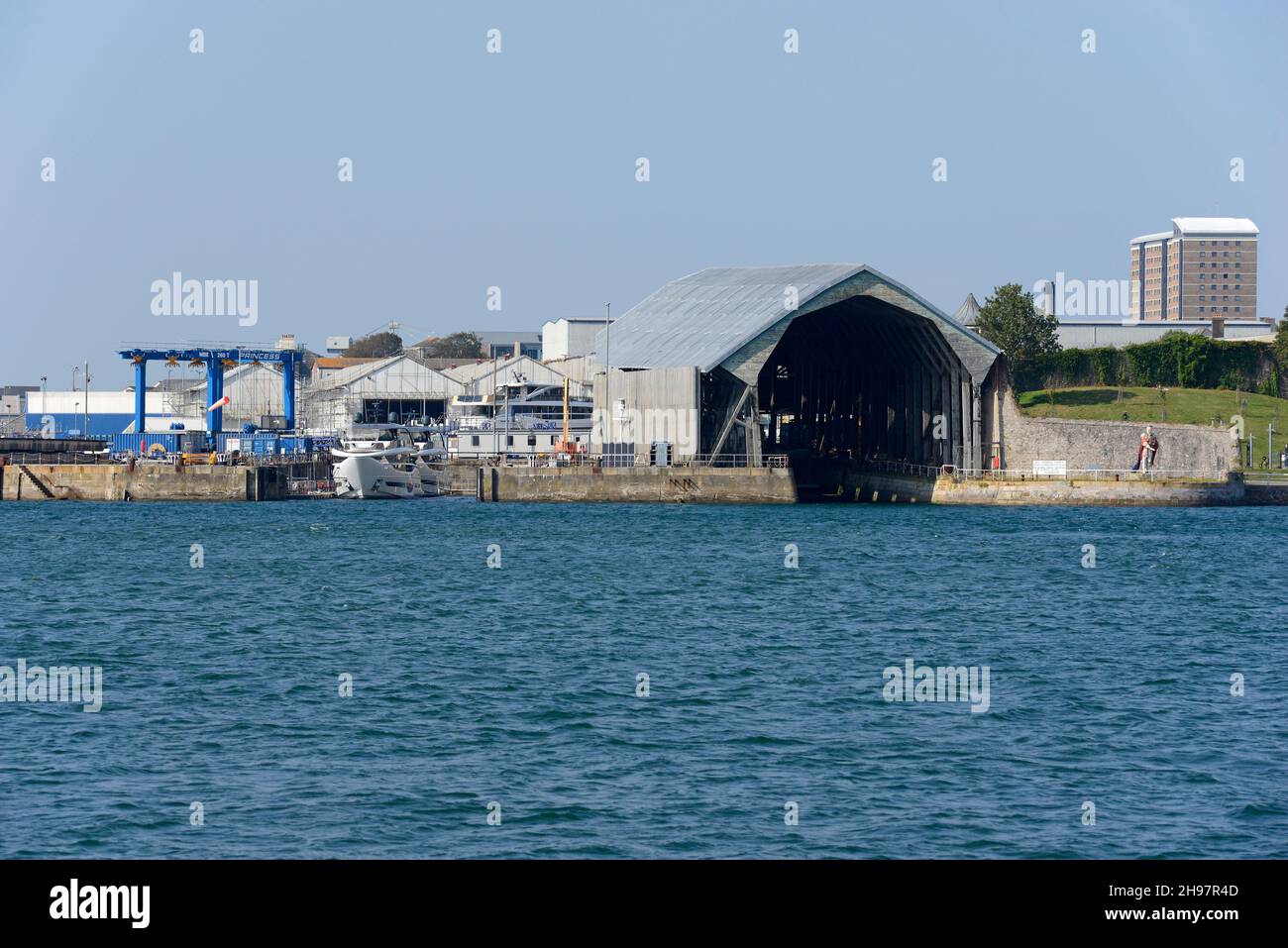 Stirling and Son's boatyard in Plymouth seen from across the water with the King Billy statue visible to the right. Stock Photo