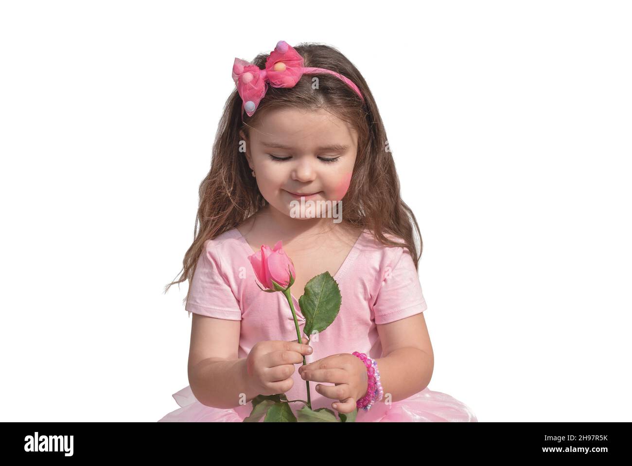 Child with a rose isolate. Girl with a pink flower in a pink dress on a ...