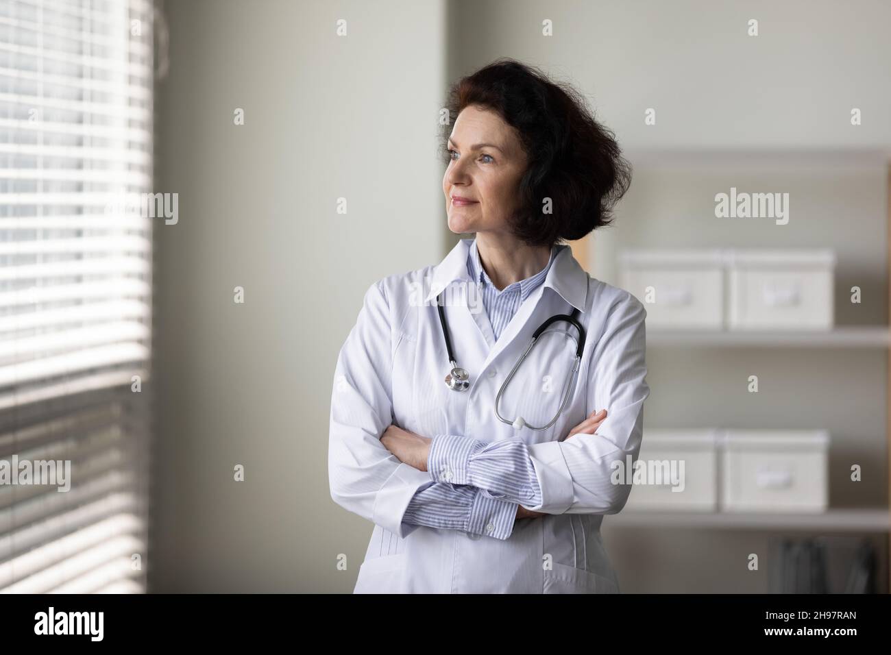 Female doctor standing window hi-res stock photography and images - Alamy