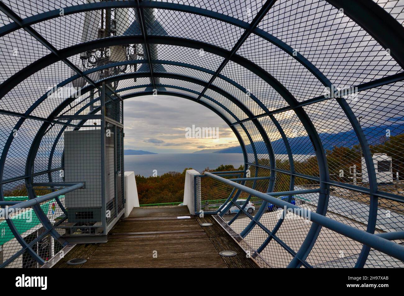 Metal tunnel bridge with wooden walkway.Strong metal bars bridge in