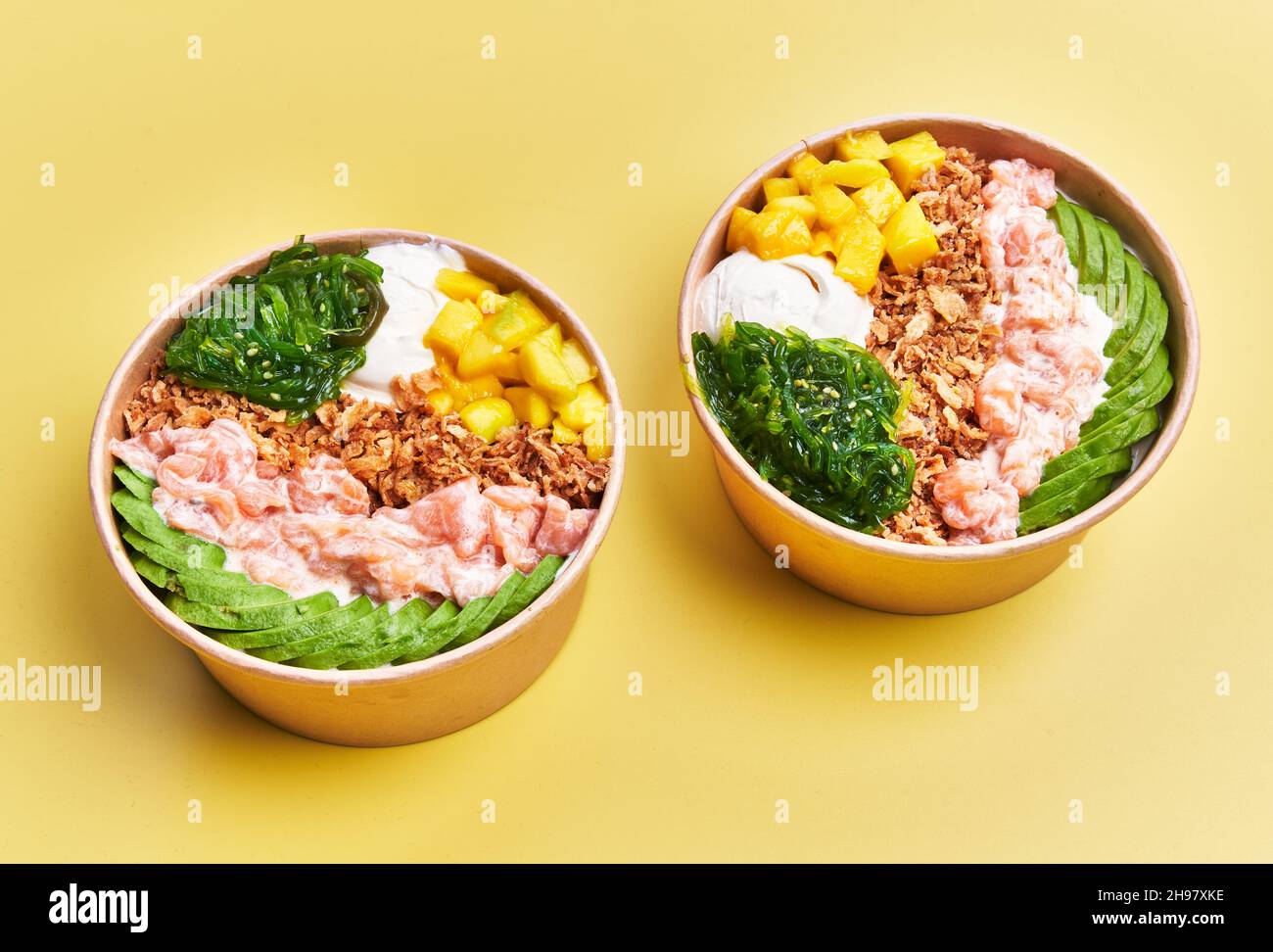 Two poke bowls over yellow background Stock Photo - Alamy