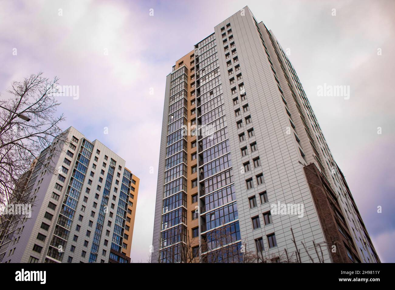 Chelyabinsk, Russia - December 2021: Modern high-rise buildings against the sky with clouds. Bottom up view. Stock Photo