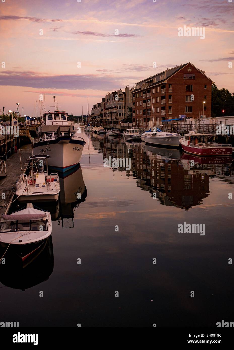 A vertical shot of boats in the port on a sunset background Stock Photo ...