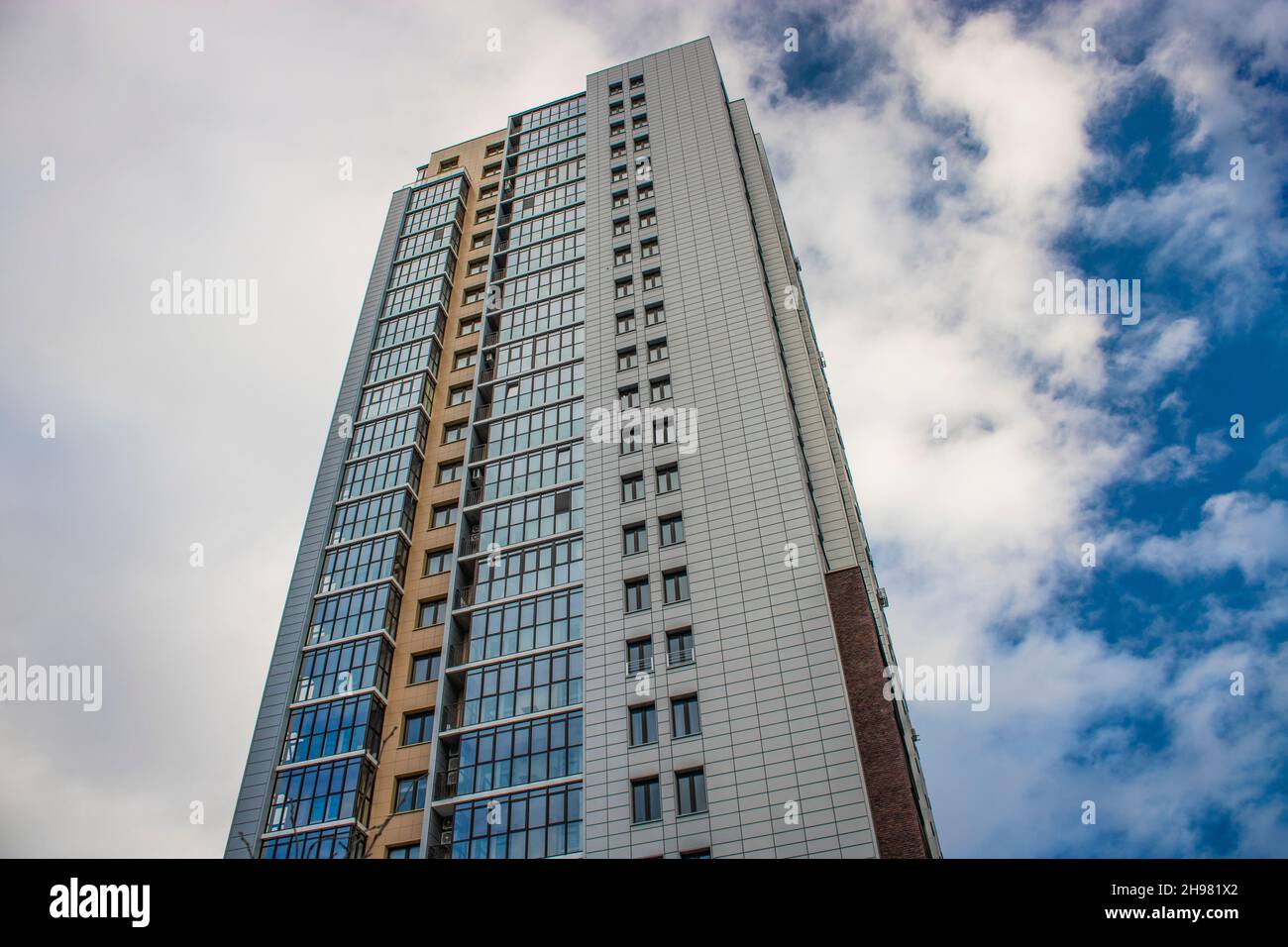 Chelyabinsk, Russia - December 2021: Modern high-rise building against the sky with clouds. Bottom up view. Stock Photo