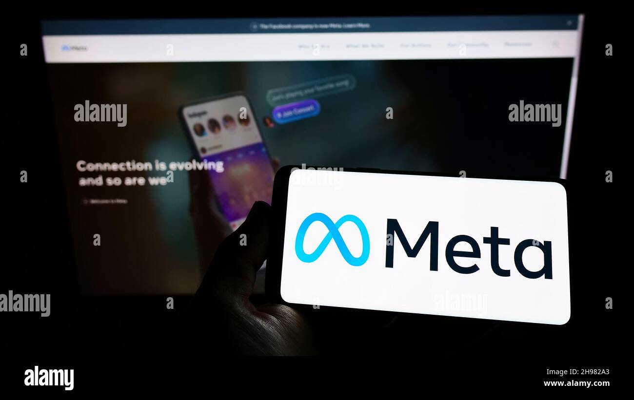 Person holding smartphone with logo of US technology company Meta