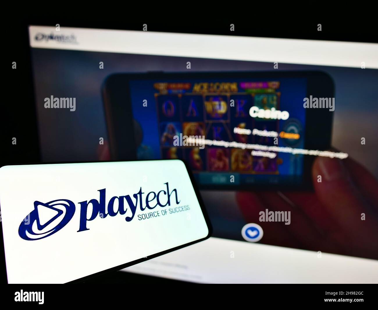 Smartphone with logo of British gambling software company Playtech plc on screen in front of business website. Focus on center of phone display. Stock Photo