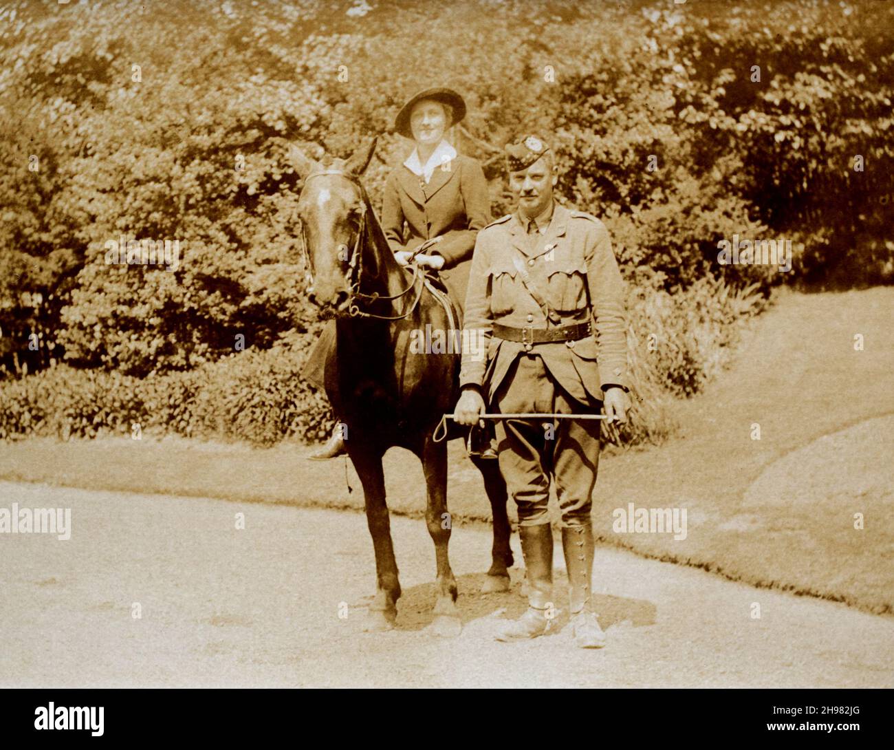 A First World War era picture of a British officer in a Scottish infantry regiment, standing besides a lady mounted on a pony. Stock Photo
