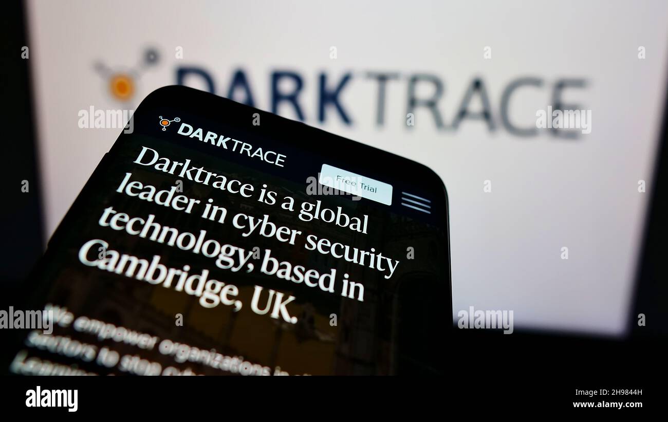 Smartphone with website of cyber defence company Darktrace plc on screen in front of business logo. Focus on top-left of phone display. Stock Photo