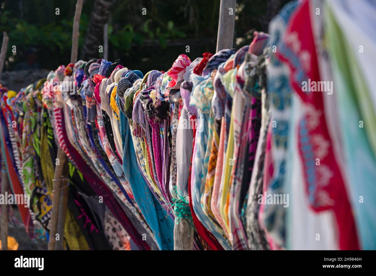 Colourful traditional fabric garments on display for sale on beach, Diani, Kenya Stock Photo