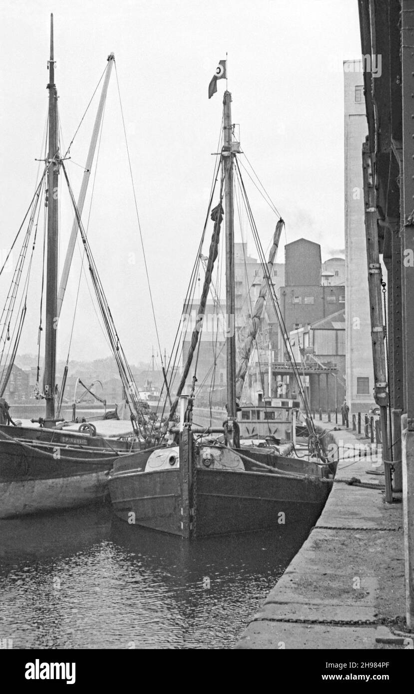The Wet Dock at the port of Ipswich, Suffolk, England, UK photographed in its last days of commercial traffic in the mid-1960s. Here Thames sailing barges are still being used, mainly for the grain trade, on the River Orwell and the North Sea. Left is ‘Spinaway C’, a wooden barge built at Ipswich in 1899. The barge on the right carries the ‘C’ pennant of Cranfield Brothers, flour millers based at the Ipswich docks – a vintage 1960s photograph. Stock Photo