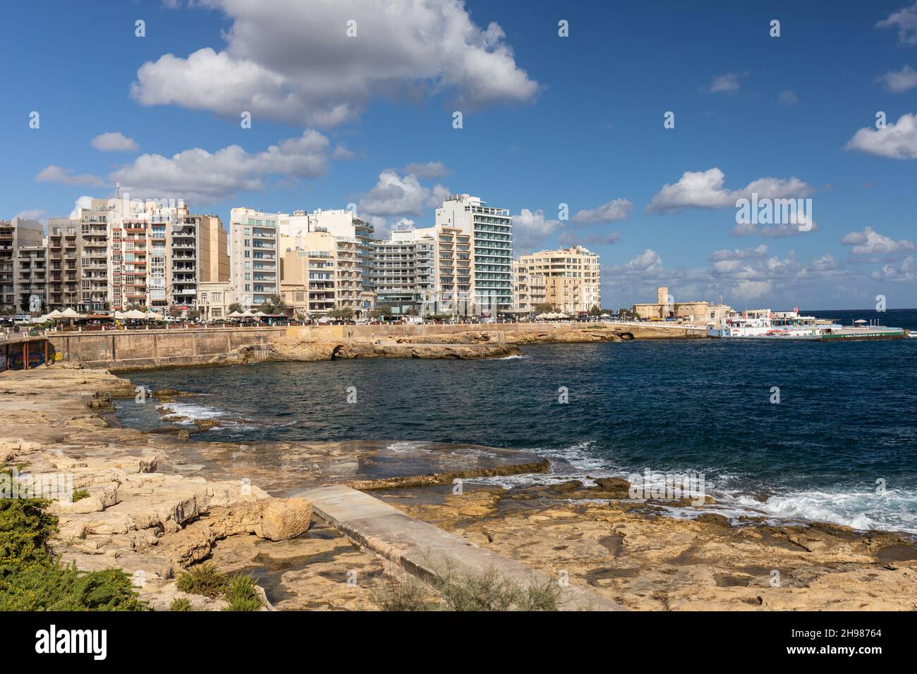 Sliema picturesque rocky beach with its many waterfront hotels and restaurants, Sliema, Malta, Europe Stock Photo