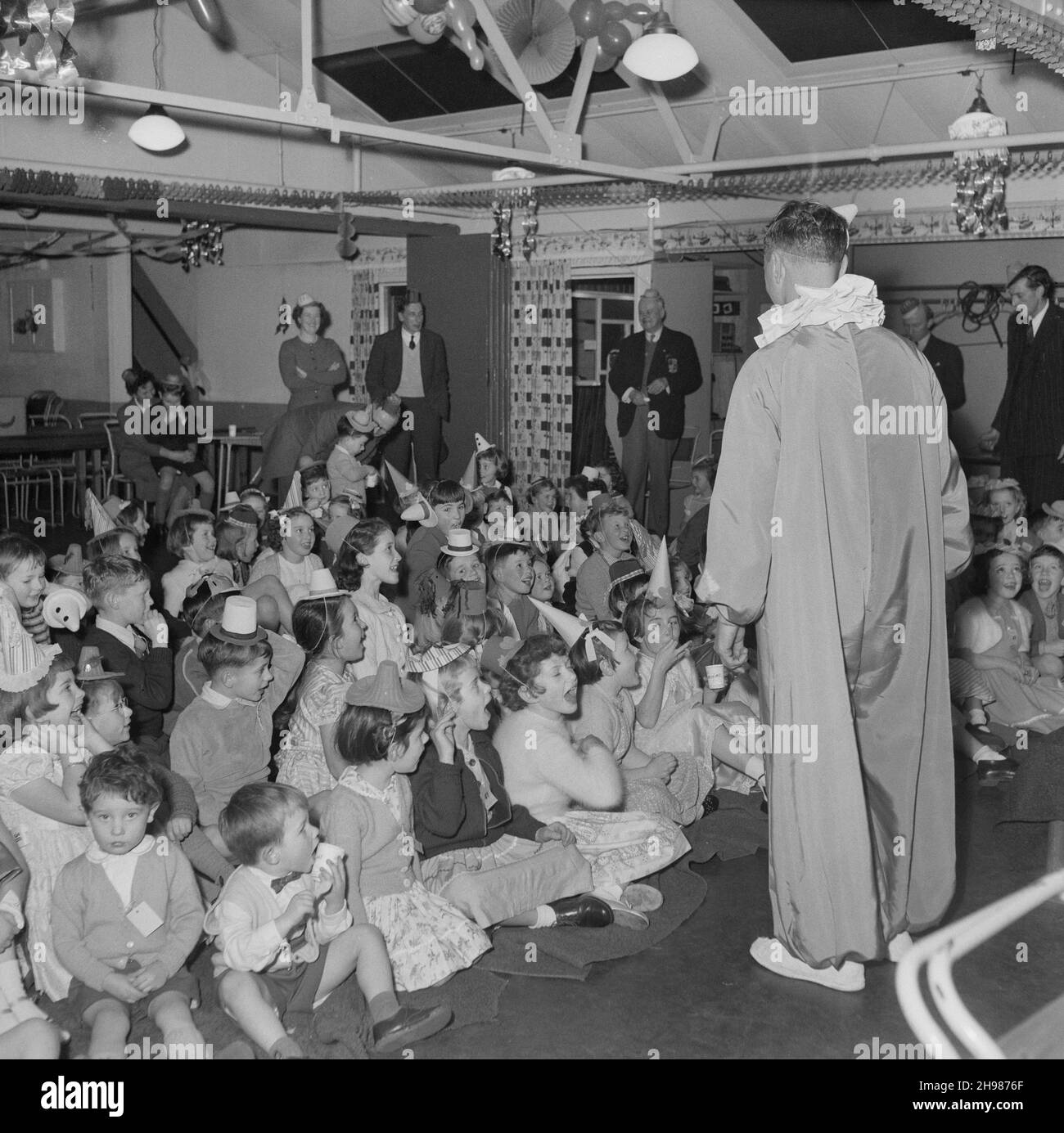 John Laing and Son Limited, Page Street, Mill Hill, Barnet, London, 14/12/1957. A clown entertaining children at the Kids Christmas party at Mill Hill. Stock Photo