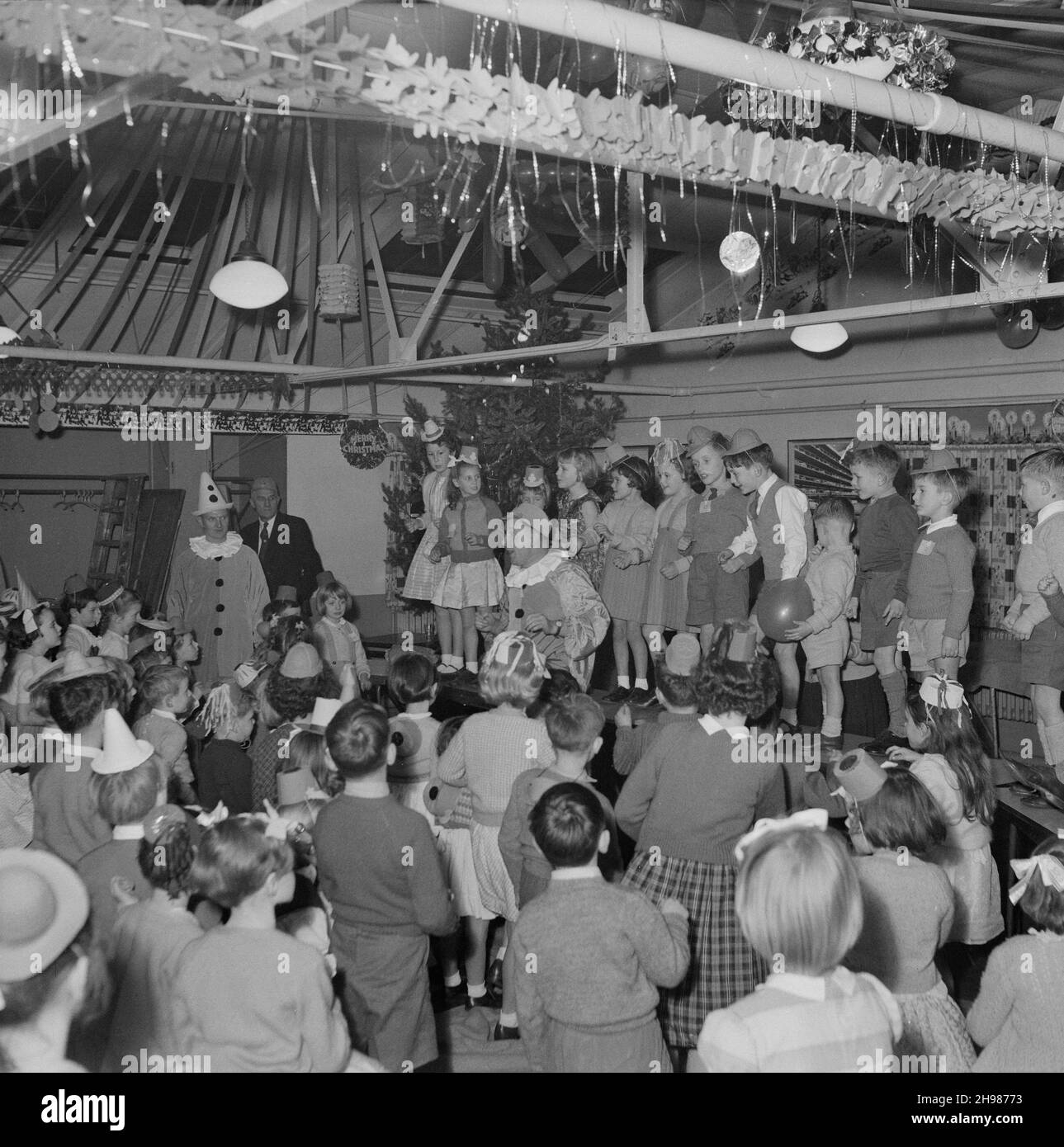 John Laing and Son Limited, Page Street, Mill Hill, Barnet, London, 13/12/1958. Two men, dressed as clowns, entertaining children at a children's Christmas party at Mill Hill. Stock Photo