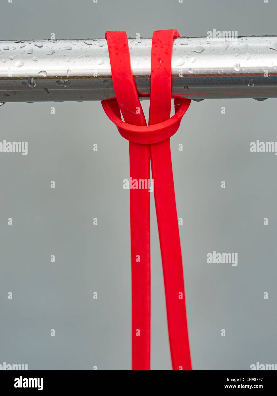 Close-up of a rubber elastic band training knot hanging on a workout  crossbar. Wourkout gym after the rain without people Stock Photo - Alamy