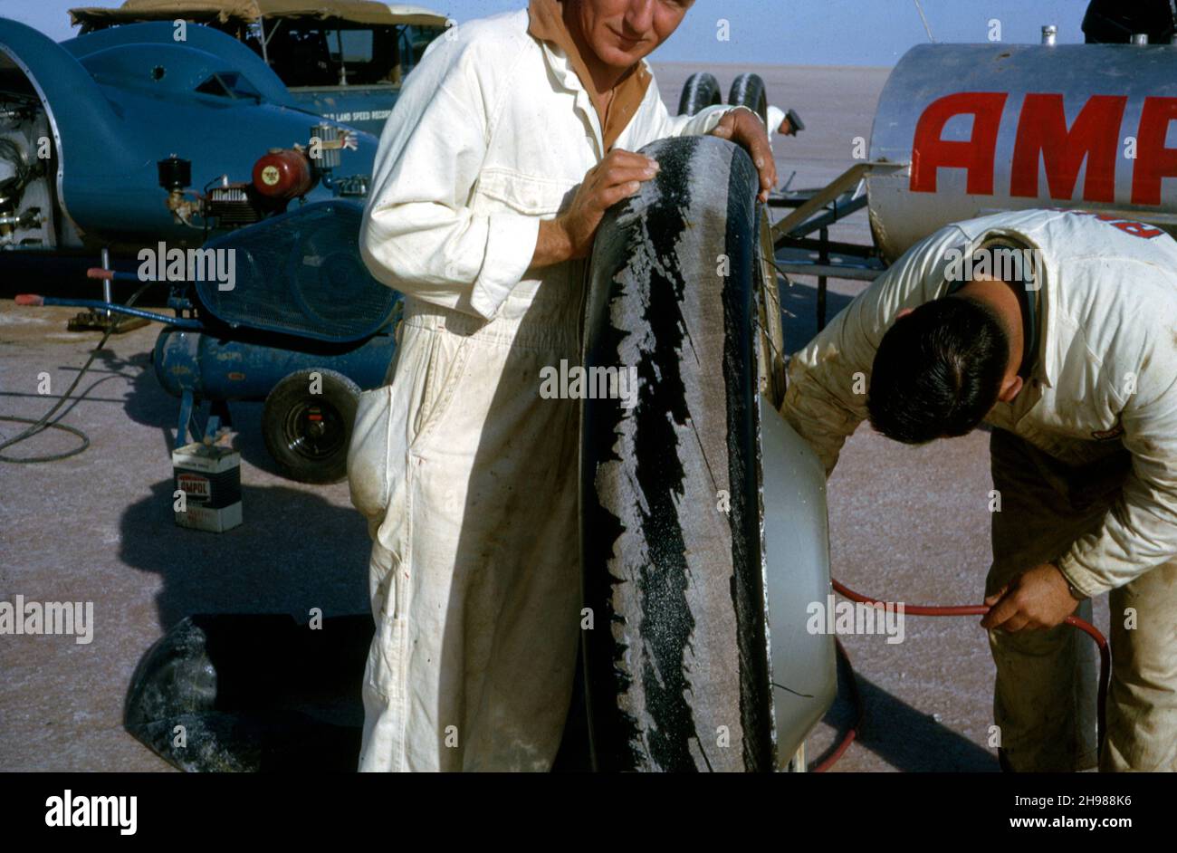 Mechanics inflating one of Bluebird CN7's tyres for Doanld Campbell's World Land Speed Record attempt, Lake Eyre, Australia, 1964. Stock Photo