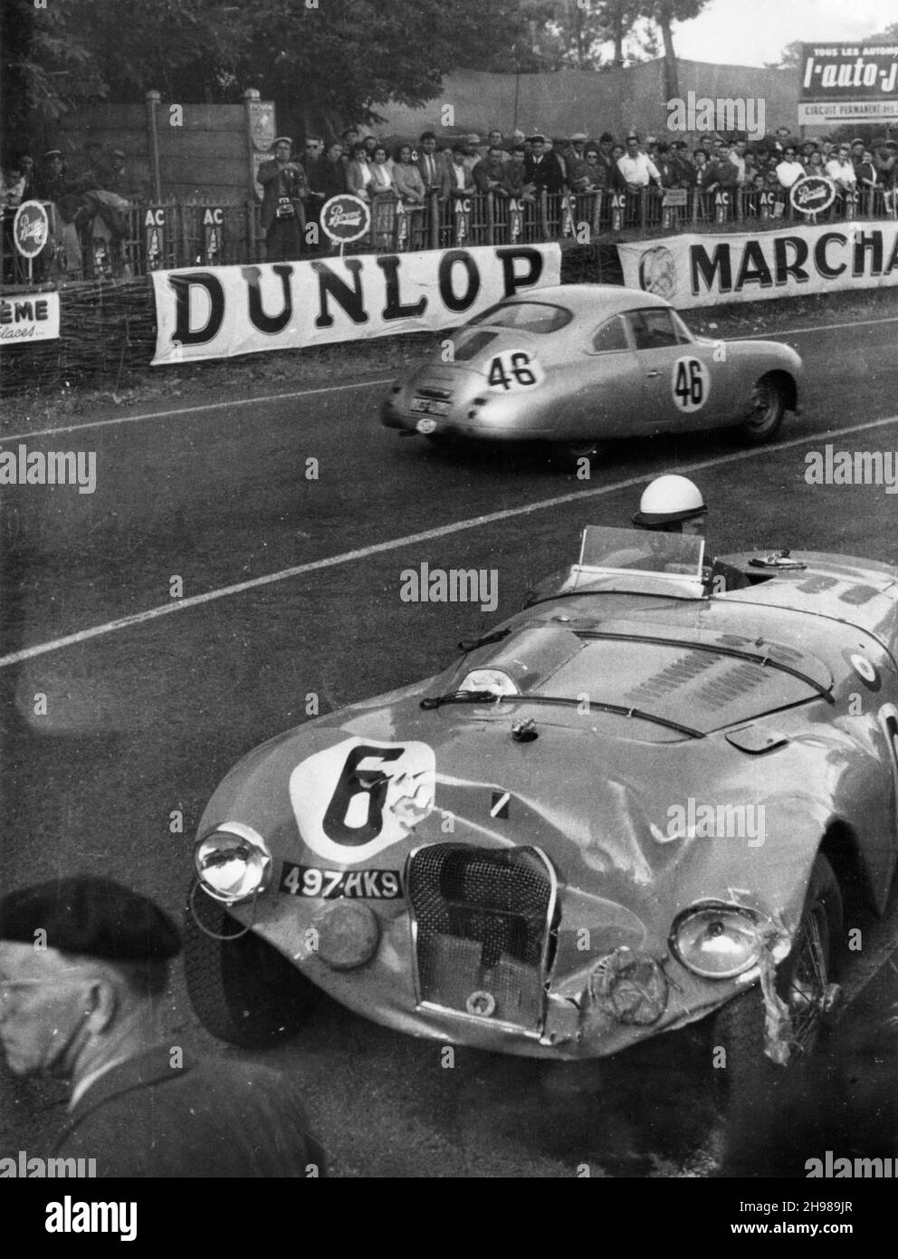 Crashed Talbot Lago of Andre Chambas and Charles de Cortanze, Le Mans 24 Hour Race, France, 1953. The Porsche 356 of Gonzague Olivier and Eugene Martin passes in the background. Stock Photo