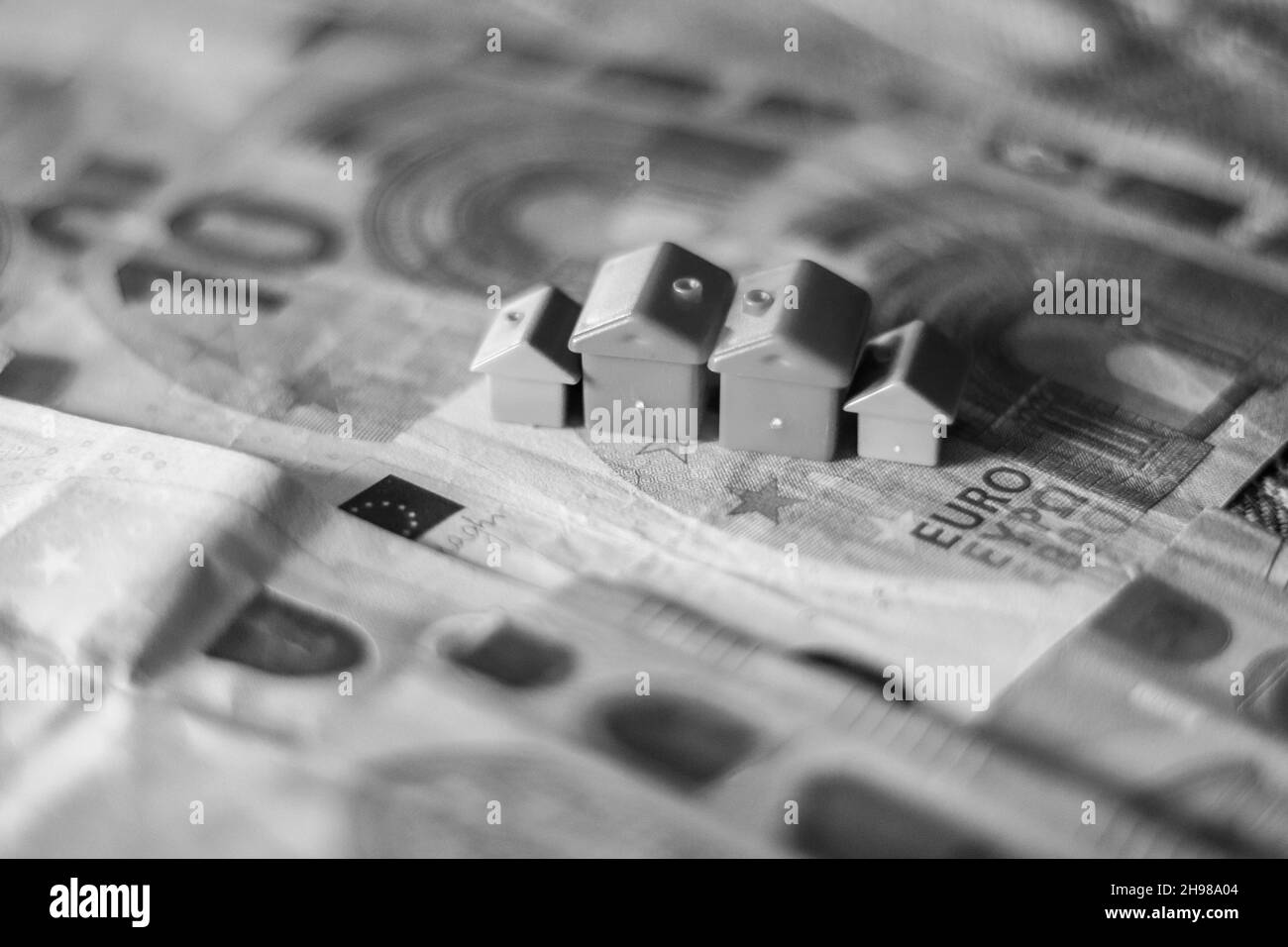 table covered with Euro banknotes with houses on top. Real estate investment concept Stock Photo