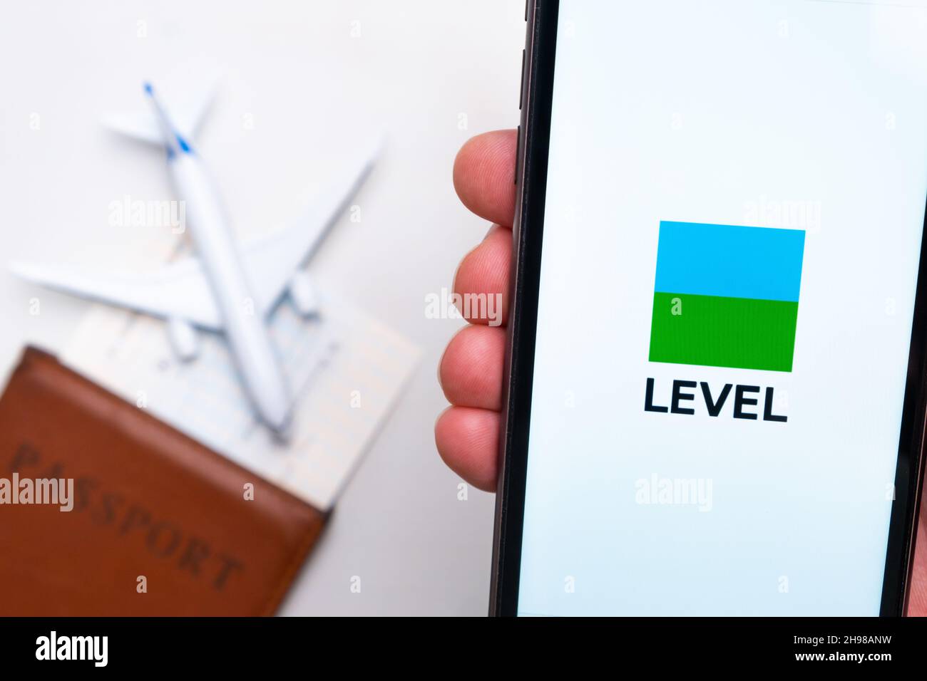 Level Airline logo on the mobile phone screen with a plane, passport