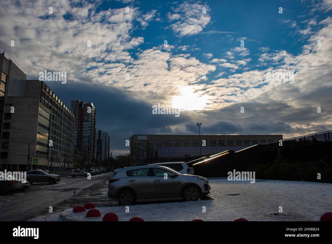Winter urban scene. A place with a road, cars and buildings. City landscape. Stock Photo