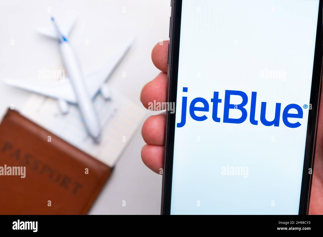 jetBlue Airline application is displayed on the smartphone screen. There is a blurry plane, passport and boarding pass on the background. November 2021, San Francisco, USA Stock Photo