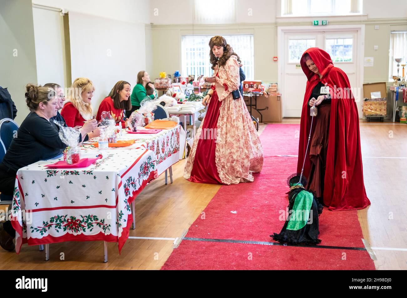Judges (left) watch on as a woman walks her dog down the catwalk during