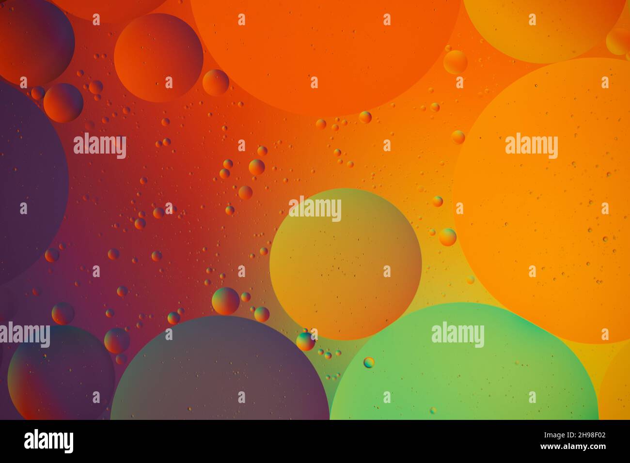 Abstract colorful Background, purple Bubbles and circles in oily Water. Purple, orange and red colors. Macro photography. Top view. Stock Photo