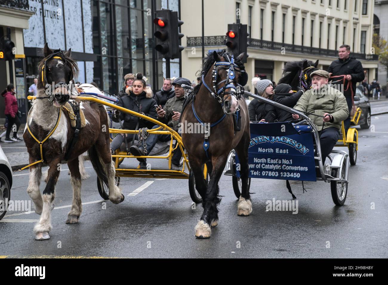 A group of Horse Carriage Rides passing by Charing Cross Station. The
