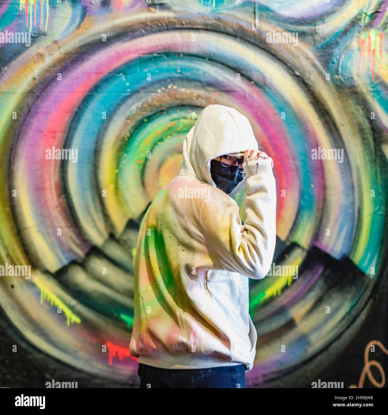 A graffiti artist blends in with their creation in the Leake Street tunnel in London during the pandemic. Stock Photo