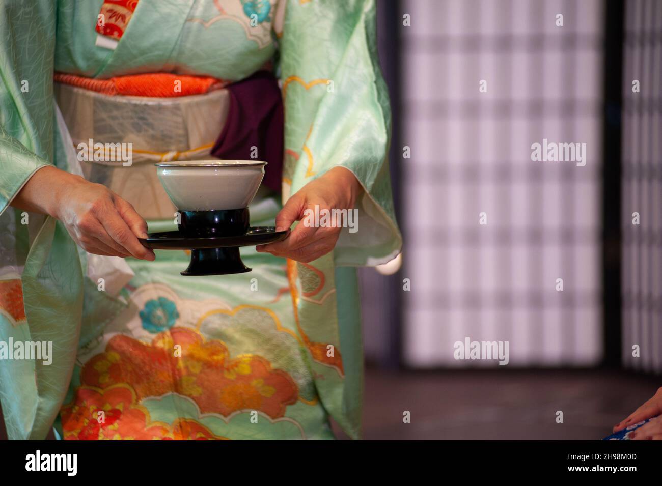 Japanese woman in traditional kimono, during the tea ceremony. Copy space. Stock Photo