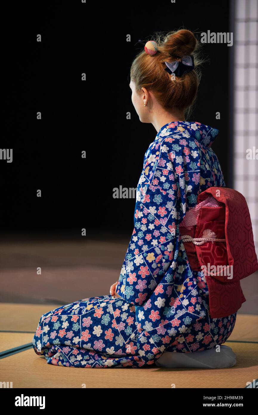 Young woman in traditional kimono in kneeling position. Seiza is the formal way of sitting down based on ancient Japanese standards. Stock Photo