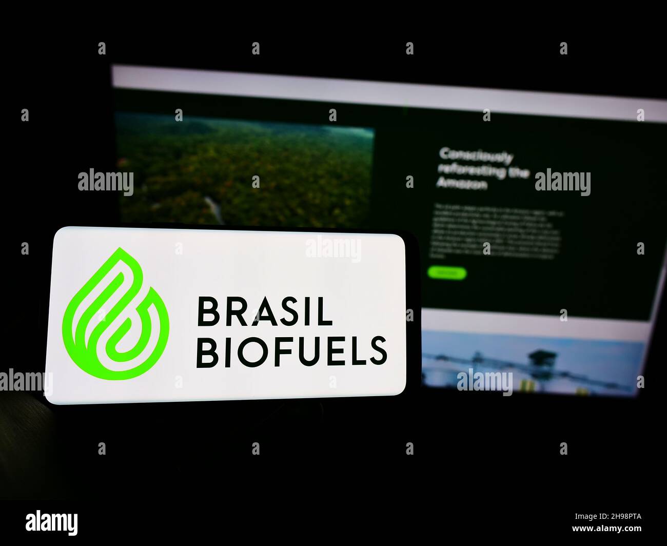 Person holding cellphone with logo of company BBF Brasil Bio Fuels S.A. (BioFuels) on screen in front of business webpage. Focus on phone display. Stock Photo