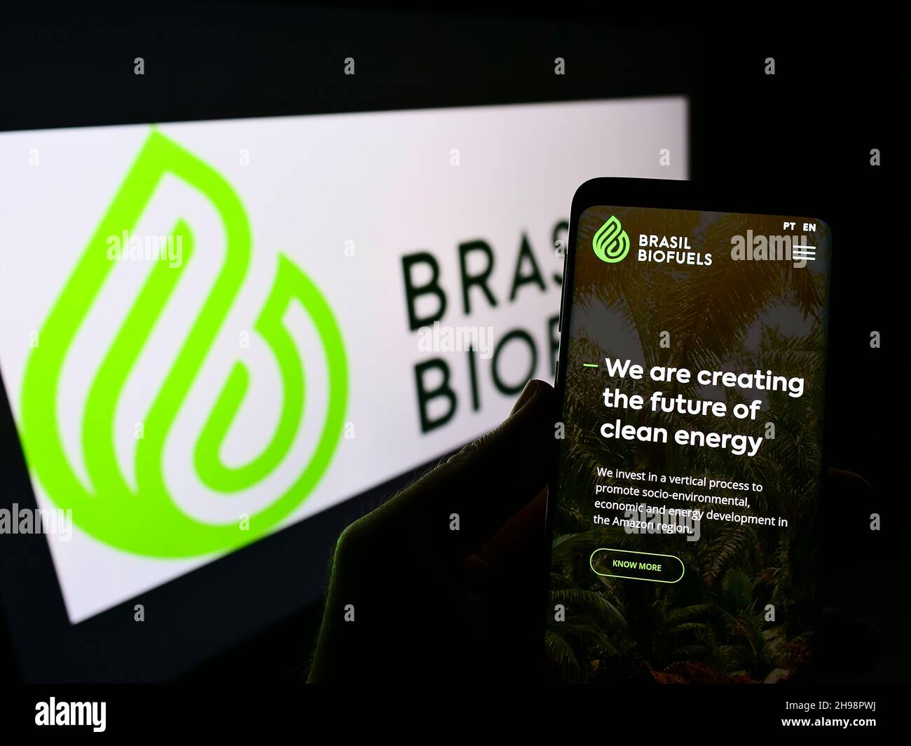 Person holding cellphone with webpage of company BBF Brasil Bio Fuels S.A. (BioFuels) on screen in front of logo. Focus on center of phone display. Stock Photo