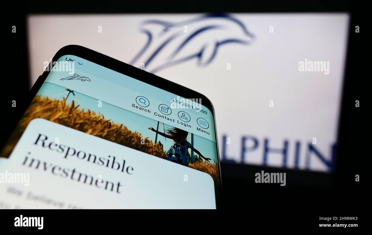 Mobile phone with website of British wealth management company Brewin Dolphin plc on screen in front of logo. Focus on top-left of phone display. Stock Photo