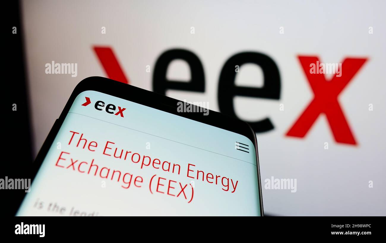 Smartphone with website of German company European Energy Exchange AG (EEX) on screen in front of business logo. Focus on top-left of phone display. Stock Photo