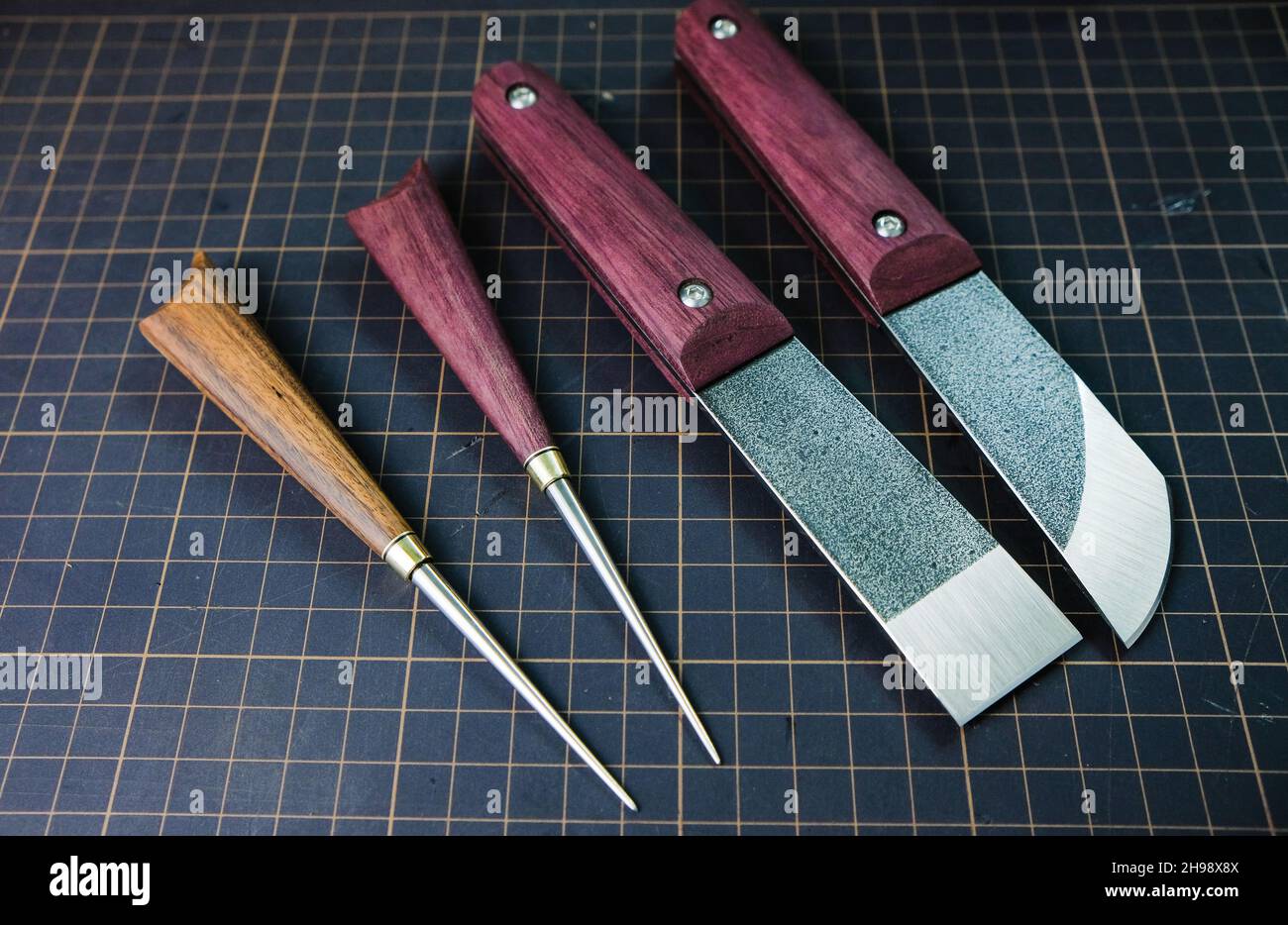 Tanner tools. Handmade Skiving knife and awl. Stock Photo
