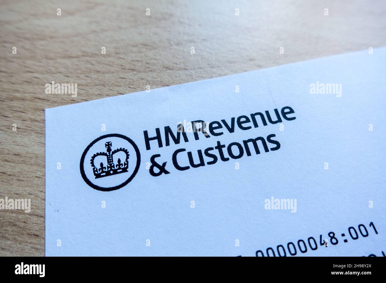 HM Revenue and Customs logo printed on a letter with a table background Stock Photo