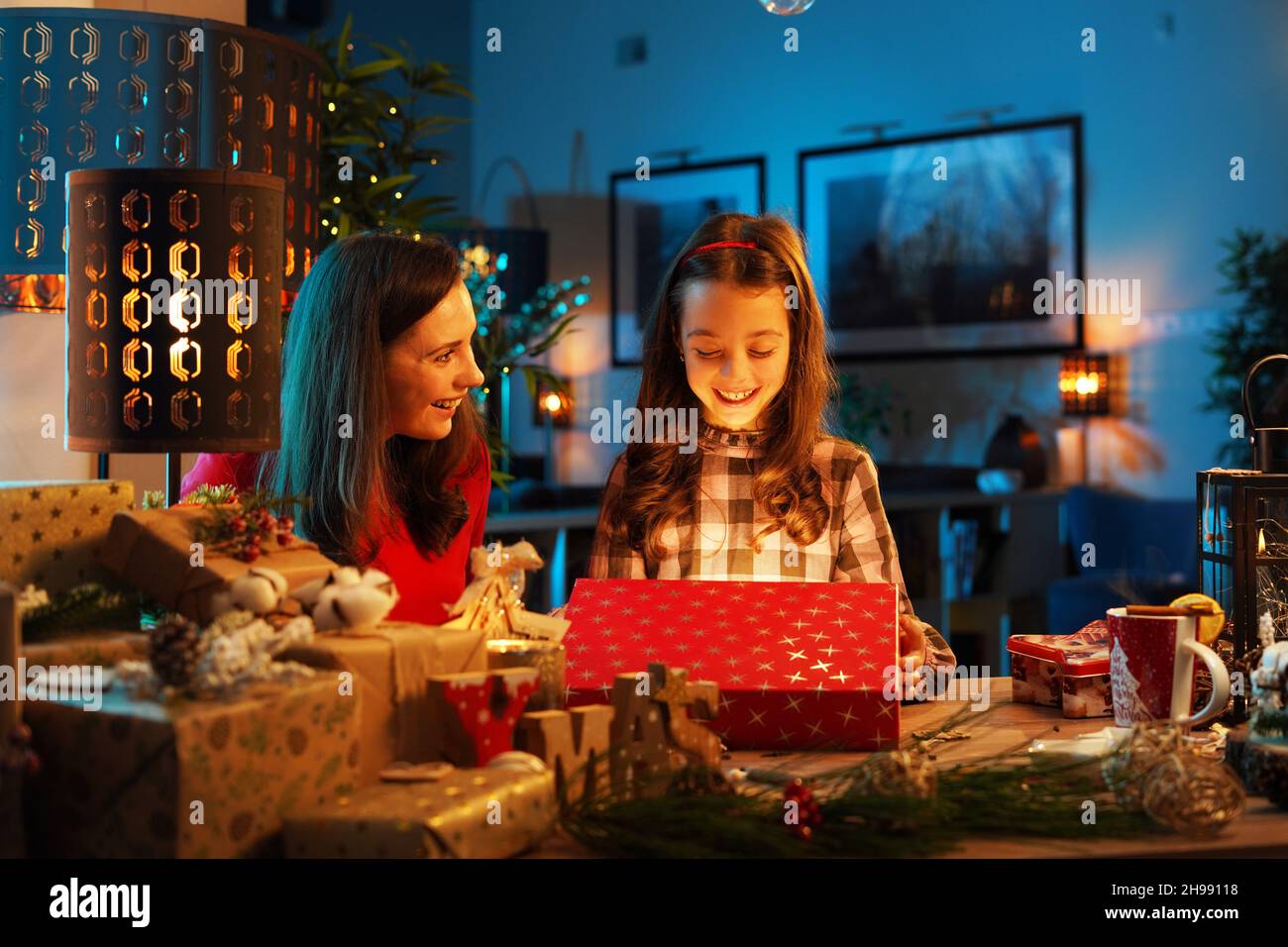 Cute daughter unboxing with mom the Christmas present - electronic device Stock Photo