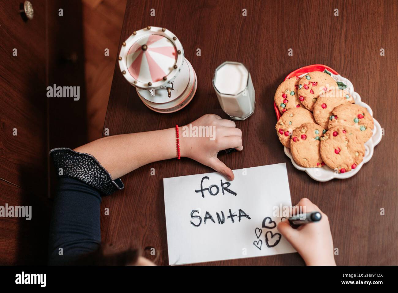 Top view of a little girl leaving cookies and glass of milk for Santa