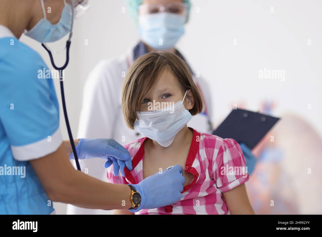 Girl being examined by pediatrician doctor with stethoscope tool Stock Photo
