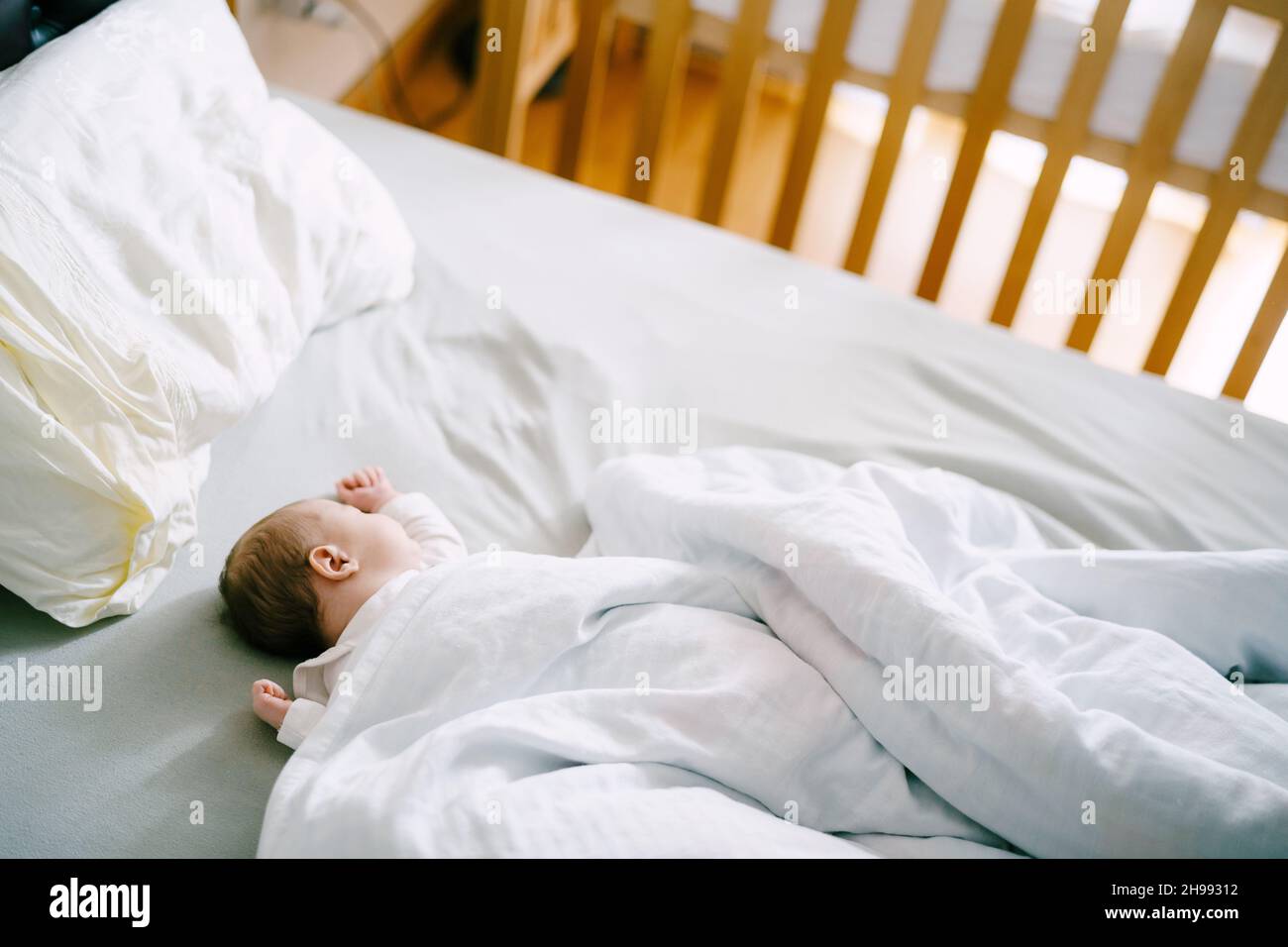 Baby sleeps in bed covered with a blanket Stock Photo Alamy