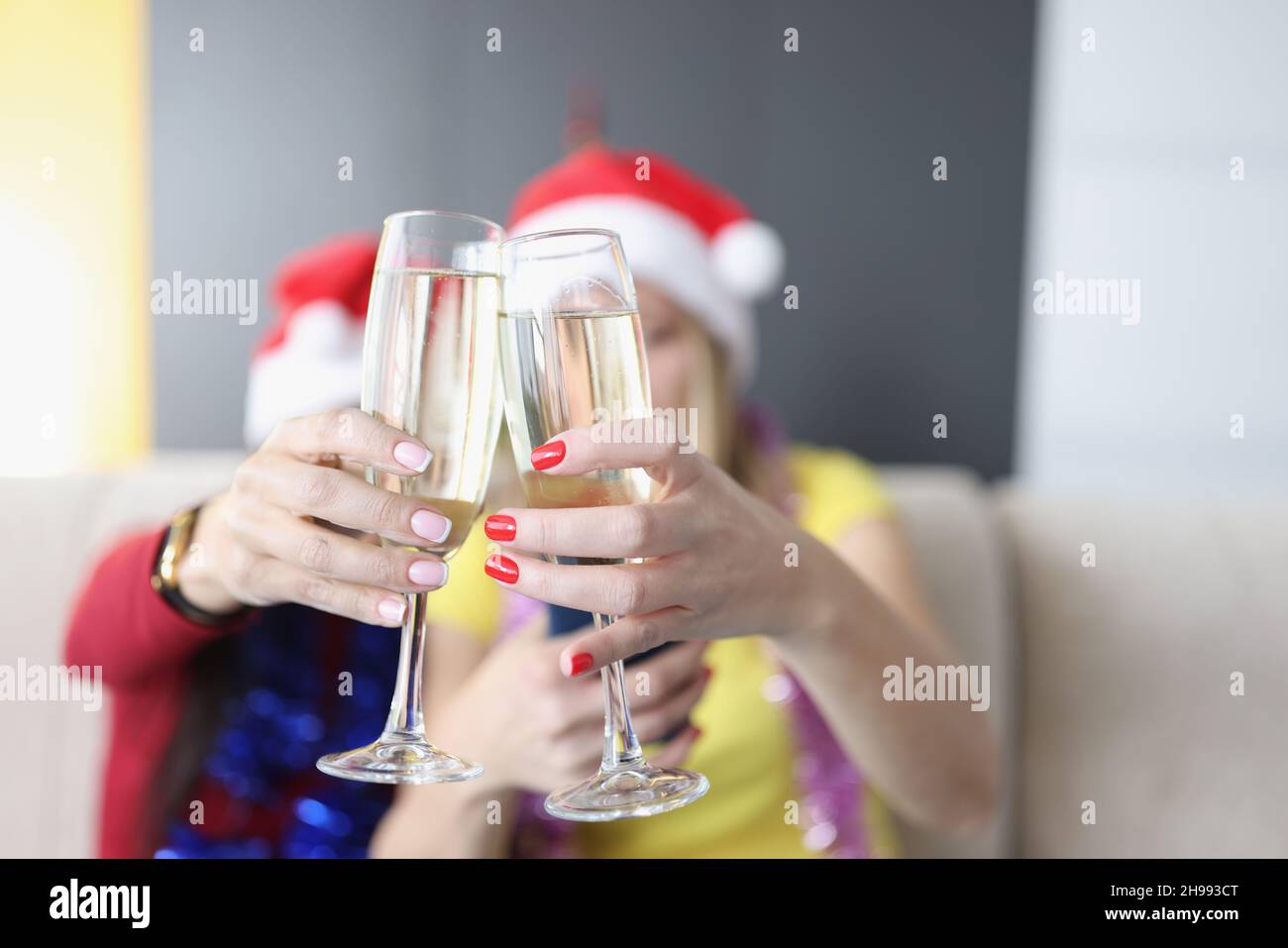 Women hold champagne drinks, glass filled with alcohol, raise toast for new year coming Stock Photo