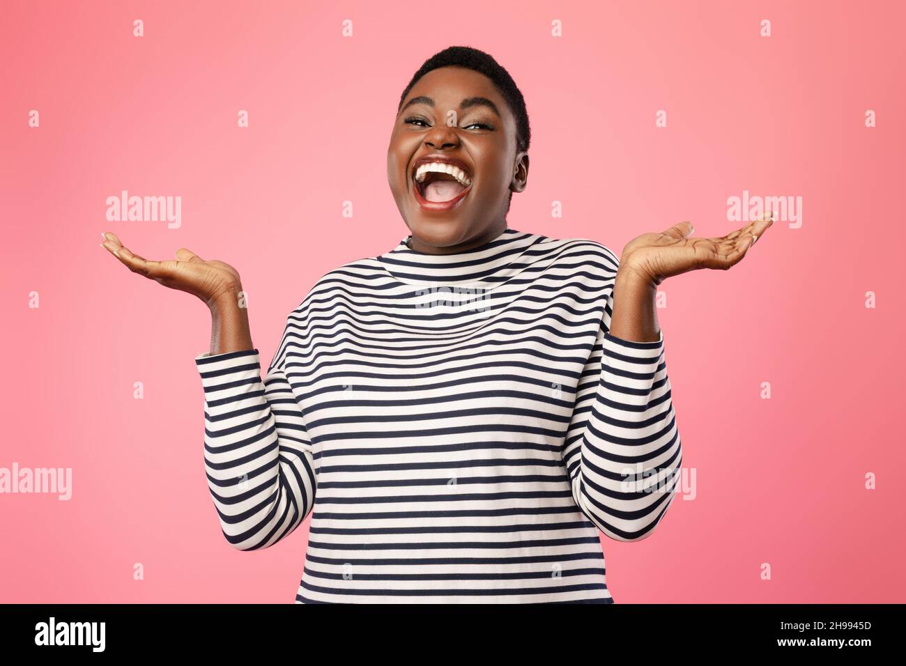 Cheerful Plus-Sized Black Lady Holding Two Invisible Objects, Pink Background Stock Photo
