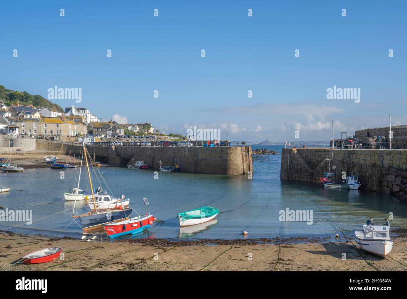 The gorgeous little fishing harbour of Mousehole with far reaching views towards St Michael's Mount. Stock Photo