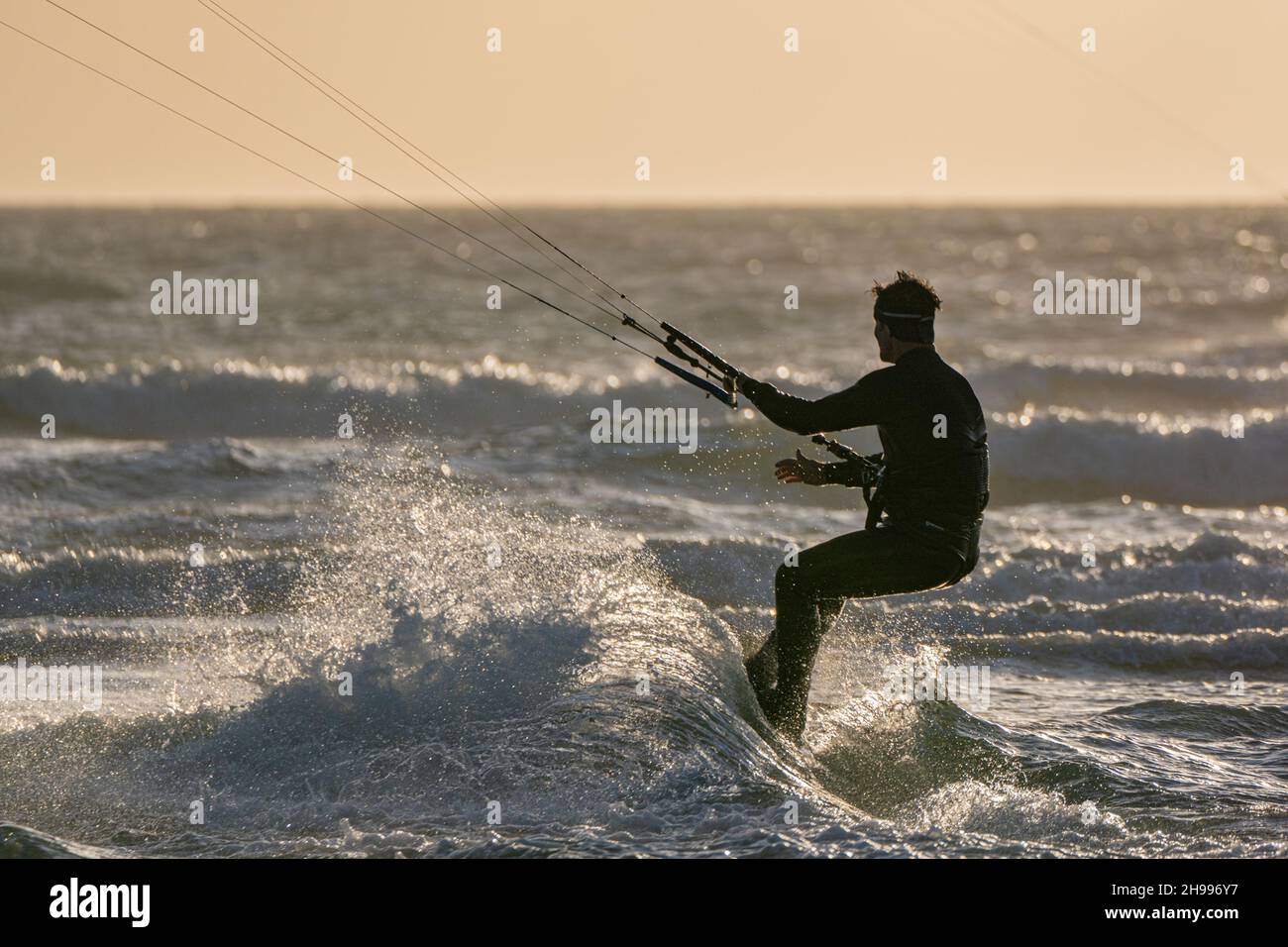 Silhouetted kite surfer at the ever popular West Wittering beach in West Sussex Stock Photo