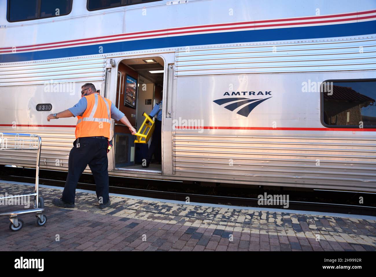 An Amtrak employee in Lamy, New Mexico, loads luggage into the Southwest Chief passenger train which runs between Chicago and Los Angeles. Stock Photo