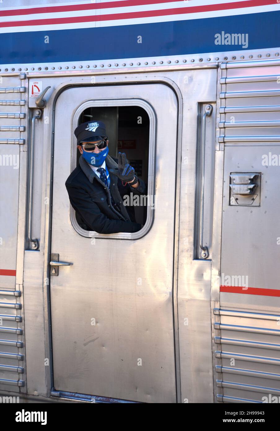 An Amtrak train conductor waves as the Southwest Chief departs Lamy, New Mexico, en route from Chicago to Los Angeles. Stock Photo