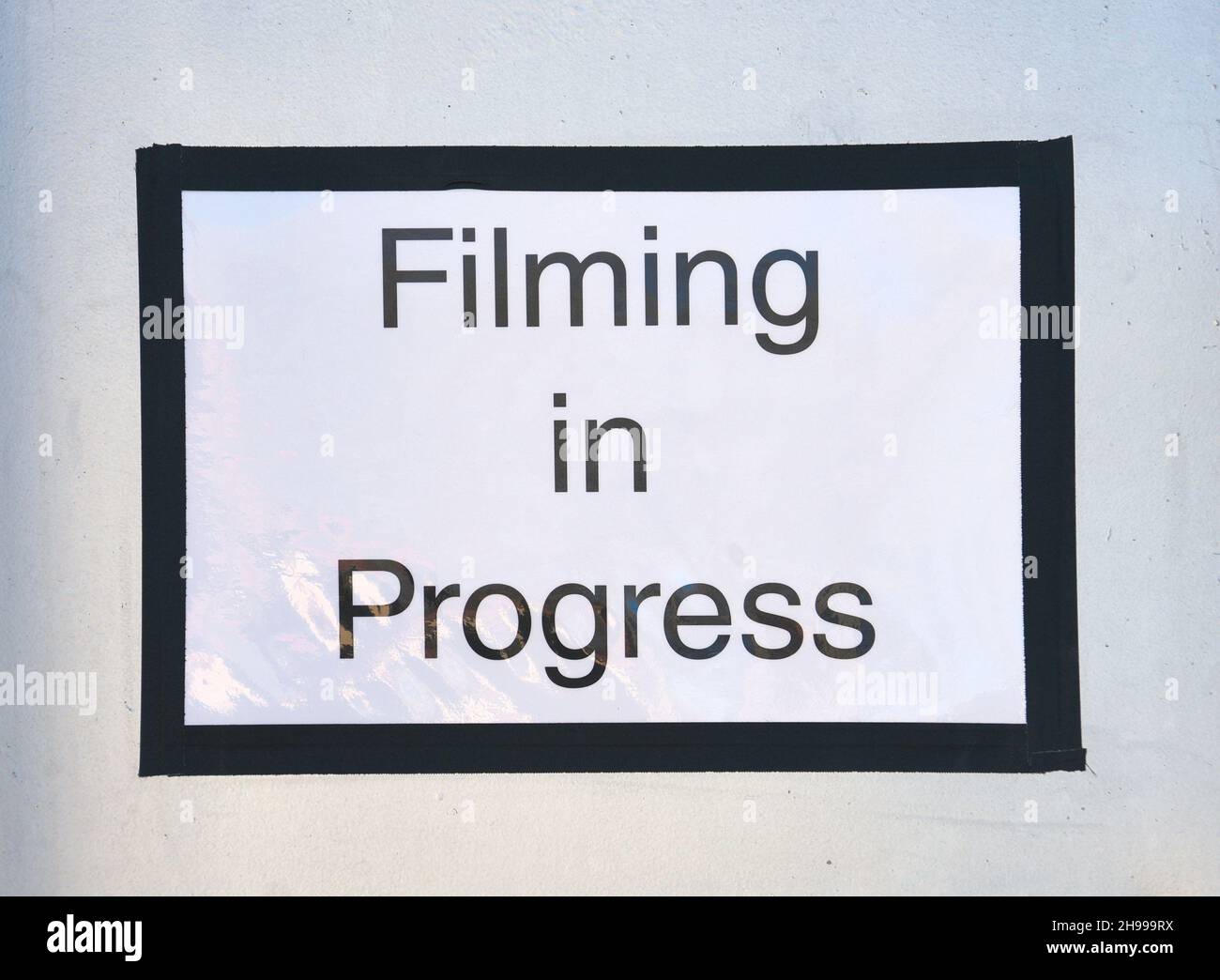 A sign alerts passengers waiting for their Amtrak train at the Lamy, New Mexico, station that a motion picture is being filmed in the area. Stock Photo